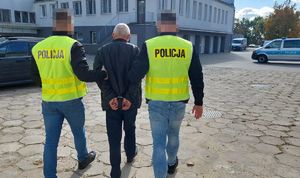 Policjanci prowadzą zatrzymanego mężczyznę