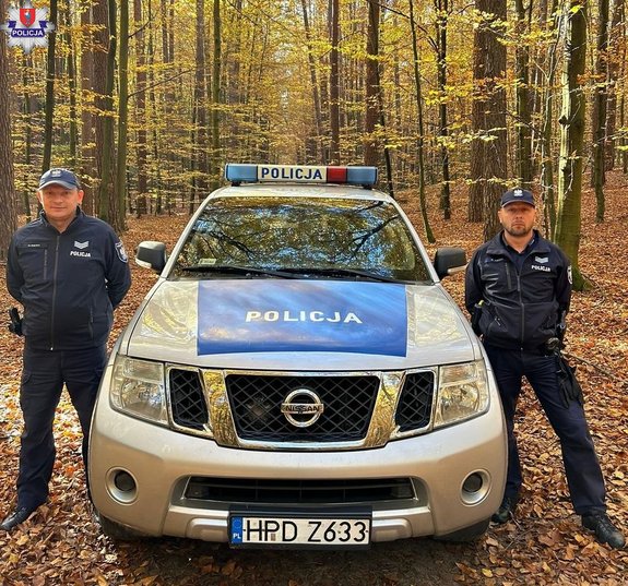 policjanci przy radiowozie w lesie