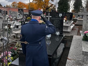 policjant w mundurze oddaje hołd zmarłemu policjantowi