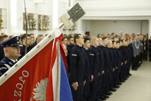 W pierwszym planie zdjęcia widzimy Sztandar Komendy Wojewódzkiej Policji w Lublinie. W drugim planie zdjęcia młodzi funkcjonariusze ubrani w granatowe mundury z napisami policja.