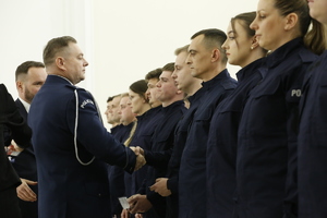 Komendant Wojewódzki Policji w Lublinie wręcza legitymację służbową nowemu policjantowi.