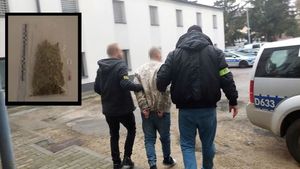 policjanci prowadzą zatrzymanego mężczyznę