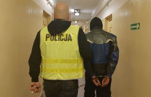 policjant prowadzi zatrzymanego mężczyznę