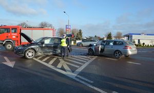 rozbite auta na skrzyżowaniu, obok nich stoją policjanci