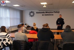 policjant rozmawia ze studentami w czasie ich wizyty w komendzie