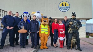 Wspólne zdjęcie funkcjonariuszy z maskotkami policji oraz pracownikami szpitala dziecięcego.