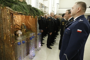 Komendant Wojewódzki Policji w Lublinie młodszy inspektor Tomasz Gil stojący przed stajenką, w której umieszczone zostało Betlejemskie Światło Pokoju.