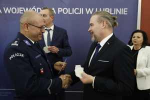 Wicewojewoda Lubelski Wojciech Wołoch naczelnik Wydziału Konwojowego Komendy Wojewódzkiej Policji w Lublinie podczas dzielenia się opłatkiem.