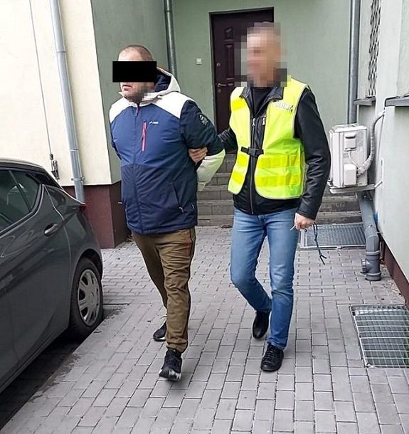 policjant prowadzi zatrzymanego