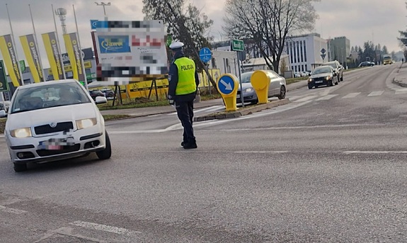 zdjęcie przedstawia policjanta kierującego ruchem na skrzyżowaniu.