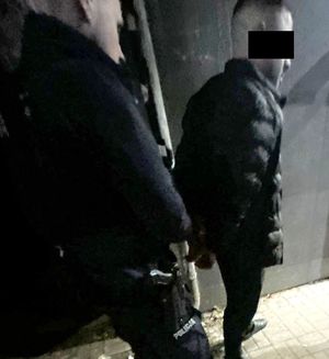 policjant z zatrzymanym poszukiwanym mężczyzną
