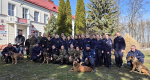 Zdjęcie grupowe uczniów szkoły mundurowej wraz z przewodnikami psów.