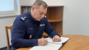 Komendant Wojewódzki Policji w Lublinie młodszy inspektor Tomasz Gil wpisuje się do księgi pamiątkowej.