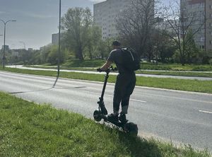 mężczyzna jadący na hulajnodze
