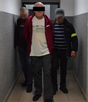 policjanci prowadzą zatrzymanego