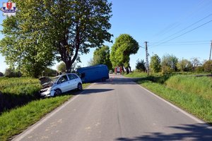 miejsce wypadku drogowego, w przydrożnym rowie stoi osobowy Opel, za nim w drzew wjechał pojazd typu bus marki Renault