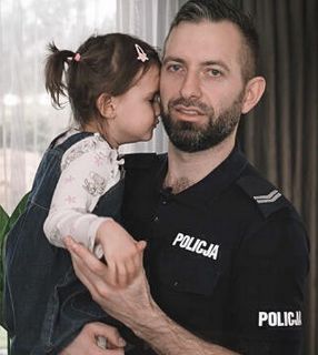 policjant trzymający na rękach córeczkę