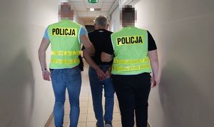 policjanci prowadzą zatrzymanego mężczyznę