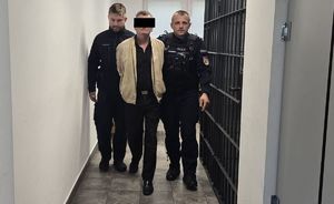 policjanci prowadzą zatrzymanego 57-latka