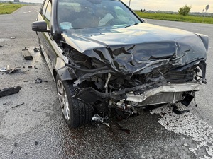 czarny pojazd z uszkodzeniami po zderzeniu z innym pojazdem