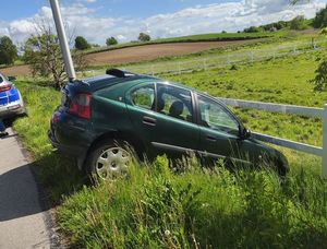 zielony Rover stojący przodem w rowie oparty o ogrodzenie