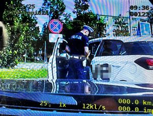 policjant stoi przy pojeździe podczas kontroli drogowej