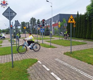 miasteczko ruchu drogowego i jeżdżący po uliczkach na rowerach uczniowie