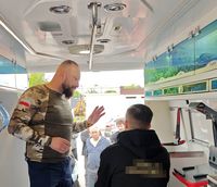 policyjny instruktor w karetce pogotowia rozmawia z kursantem w czasie kursu samoobrony