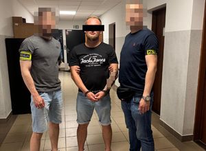 dwóch nieumundurowanych policjantów i zatrzymany mężczyzna