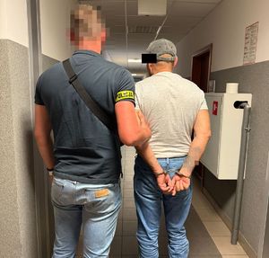 policjant prowadzi zatrzymanego mężczyznę