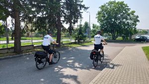 Policjanci z patrolu rowerowego jadą na rowerach ścieżką rowerową