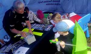 policjantka daje dziecku element odblaskowy