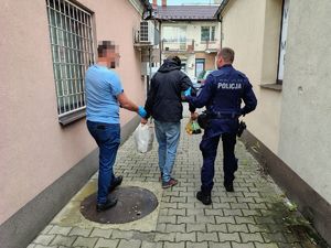 zatrzymany sprawca kradzieży trzymany przez policjantów