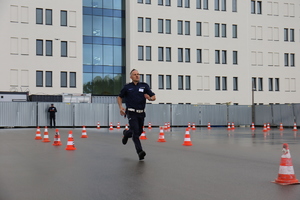 Policjant biegnie po torze przeszkód na placu apelowym