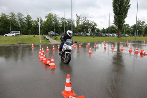 Policjant pokonuje tor przeszkód na motocyklu służbowym policji