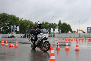 Policjant pokonuje tor przeszkód na motocyklu służbowym policji