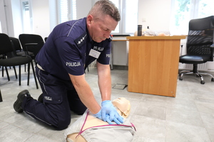 Policjant podczas uciska klatkę piersiową na fantomie