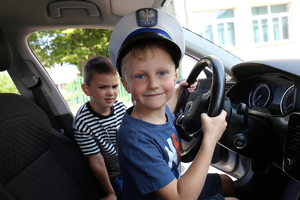 dziecko w radiowozie w policyjnej czapce