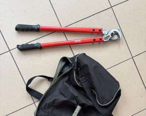 czarny plecak i nożyce z uchwytami koloru czerwonego