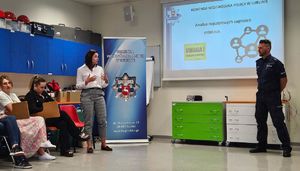 policjant podczas prelekcji z pracownikami uniwersytetu oraz pracownica podczas rozmowy