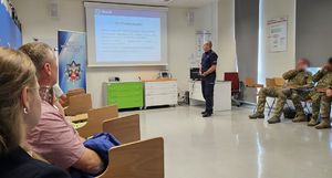 policjant podczas prelekcji z pracownikami uniwersytetu
