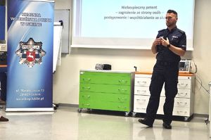 policjant podczas prelekcji z pracownikami uniwersytetu