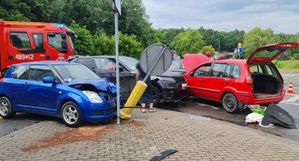 Trzy uszkodzone pojazdy osobowe na skrzyżowaniu, obok pojazd straży pożarnej