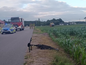 miejsce wypadku drogowego, leżąca na poboczu hulajnoga, w tle śmigłowiec LPR