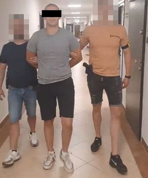 policjanci kryminalni prowadzą zatrzymanego 22-latka