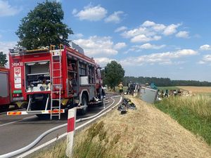 miejsce zdarzenia. Wóz strażacki. Uszkodzony samochód leżący w rowie