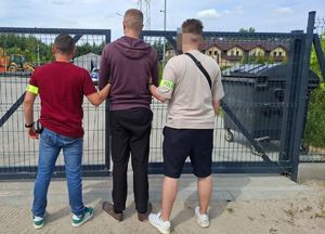 dwóch policjantów z zatrzymanym mężczyzną