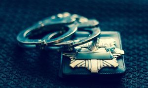 policyjna odznaka i kajdanki leżące obok