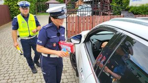 Policjantka wręcza kierowcy apteczkę.
