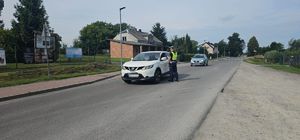 policjant podczas kontroli drogowej kierującego samochodem osobowym